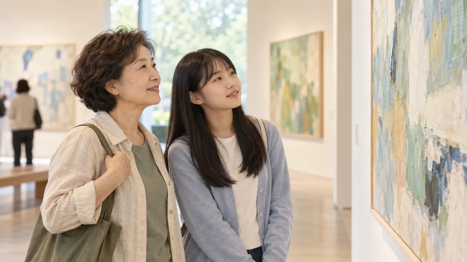 미술관에서 작품을 함께 감상하는 중장년 여성과 청소년